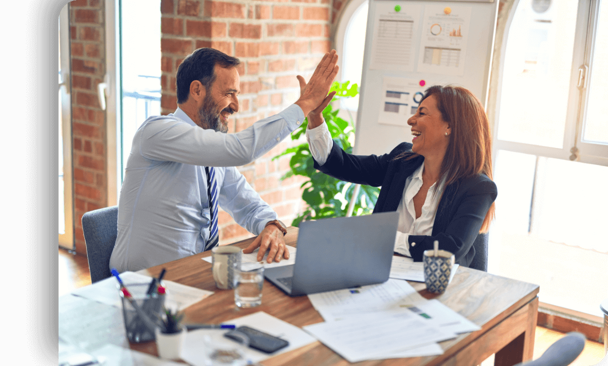 Imagen de dos personas chocando las manos en una oficina.