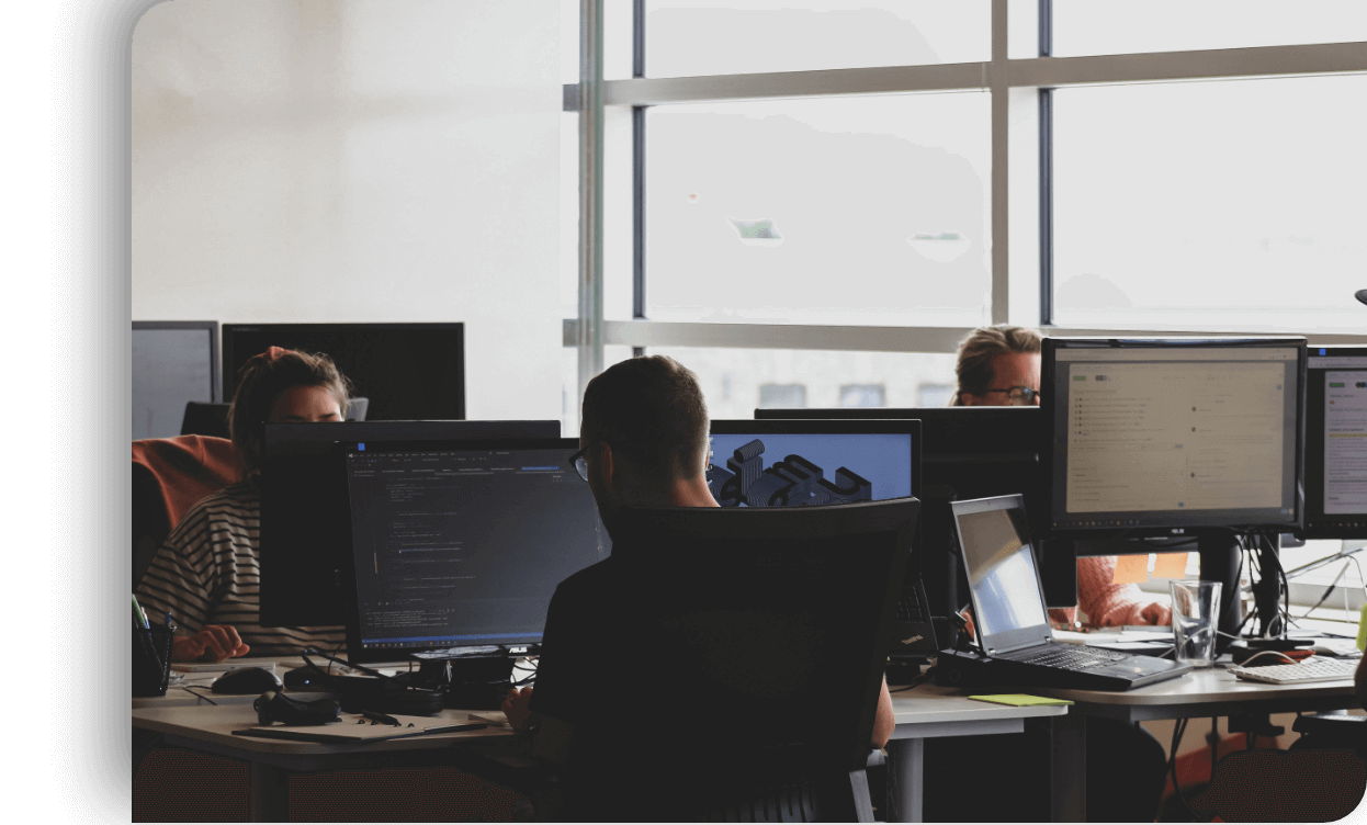 Imagen con un equipo de personas en una oficina y una de las personas está escribiendo código.