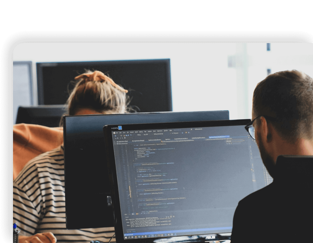 Imagen de dos personas escribiendo código.